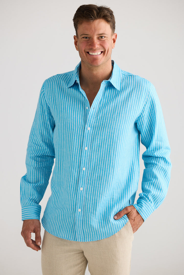 Man wearing a blue striped shirt and beige pants against a white background