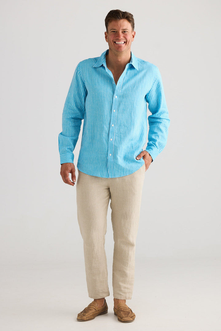 Man wearing a blue striped shirt and beige pants against a white background