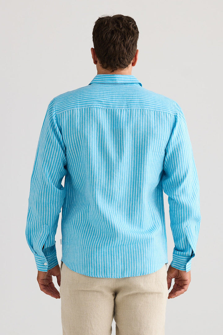 Man wearing a blue striped shirt and beige pants against a white background