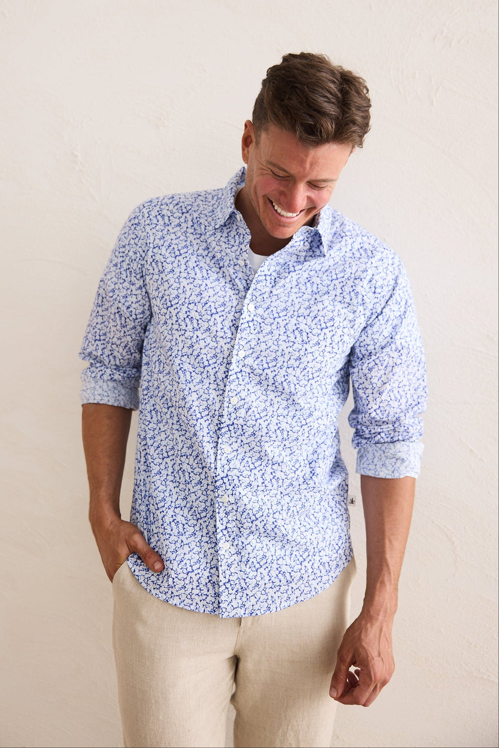 Man wearing a blue patterned shirt against a beige background