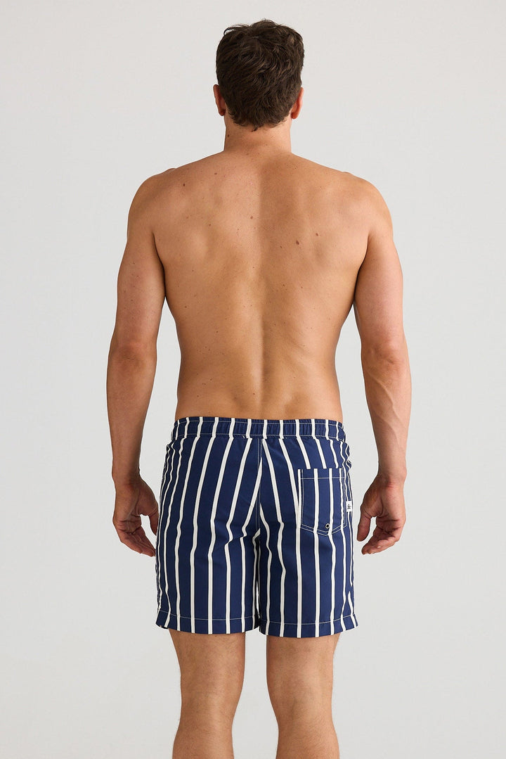 Man wearing navy striped swim shorts on a white background