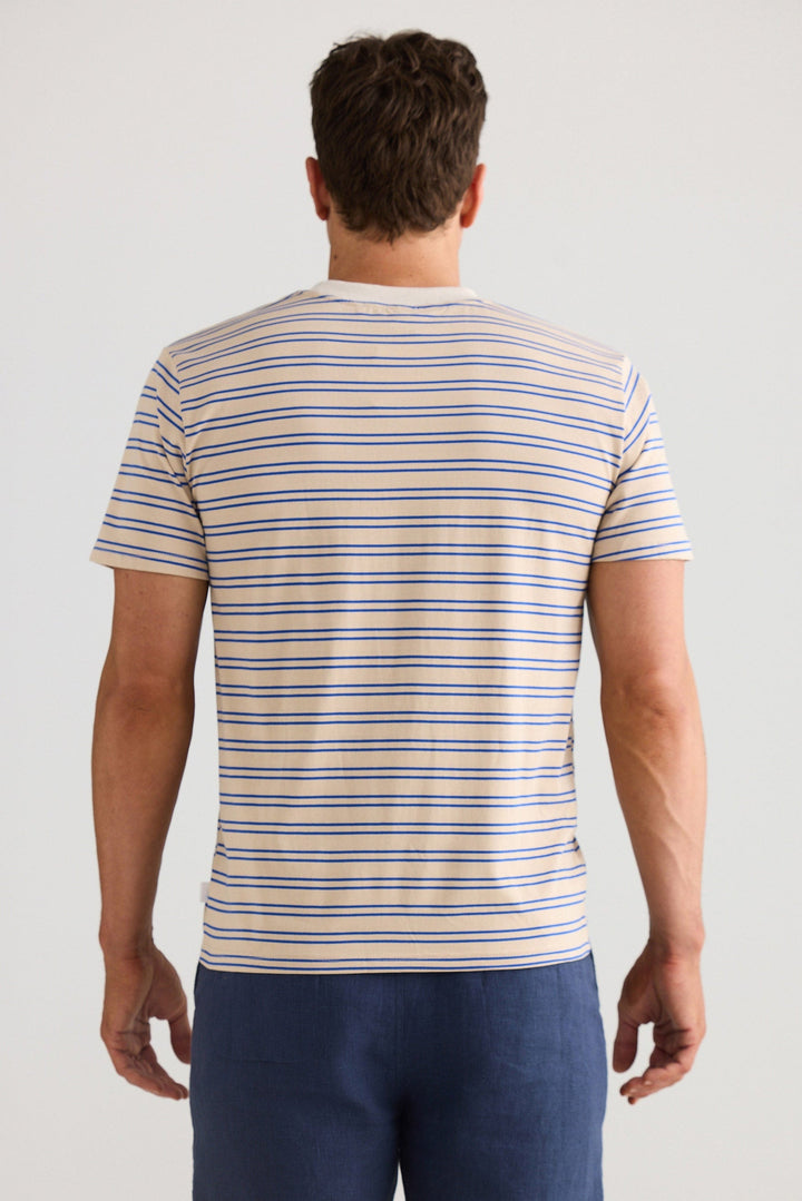 Man wearing a striped t-shirt and navy shorts on a plain background