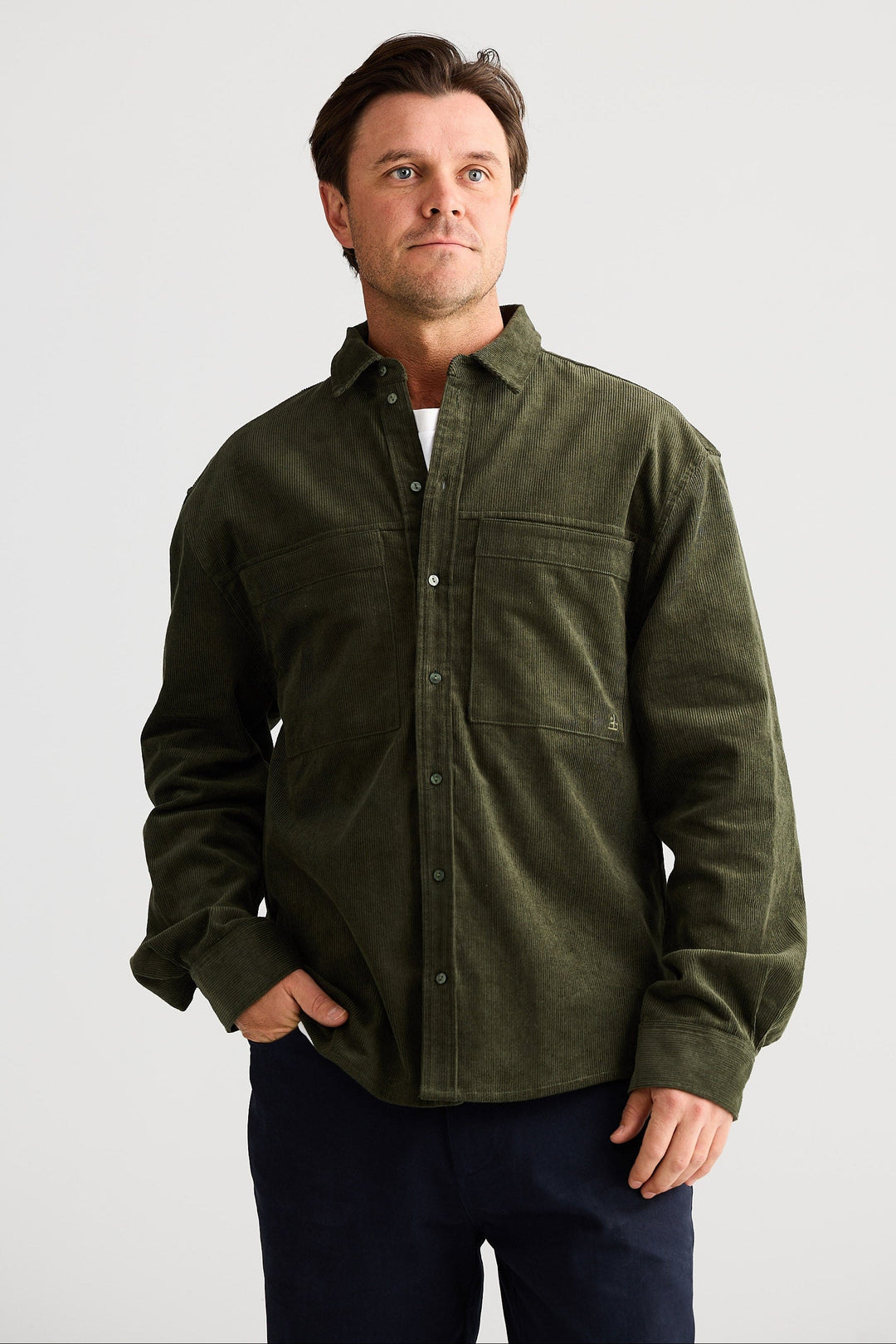 Man wearing a green shirt with a plain background