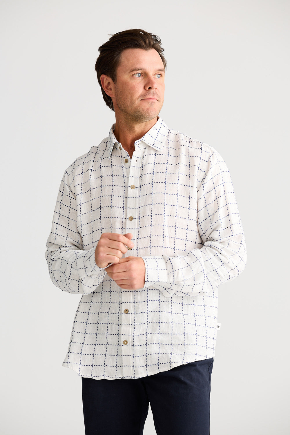Man wearing a checkered shirt against a white background