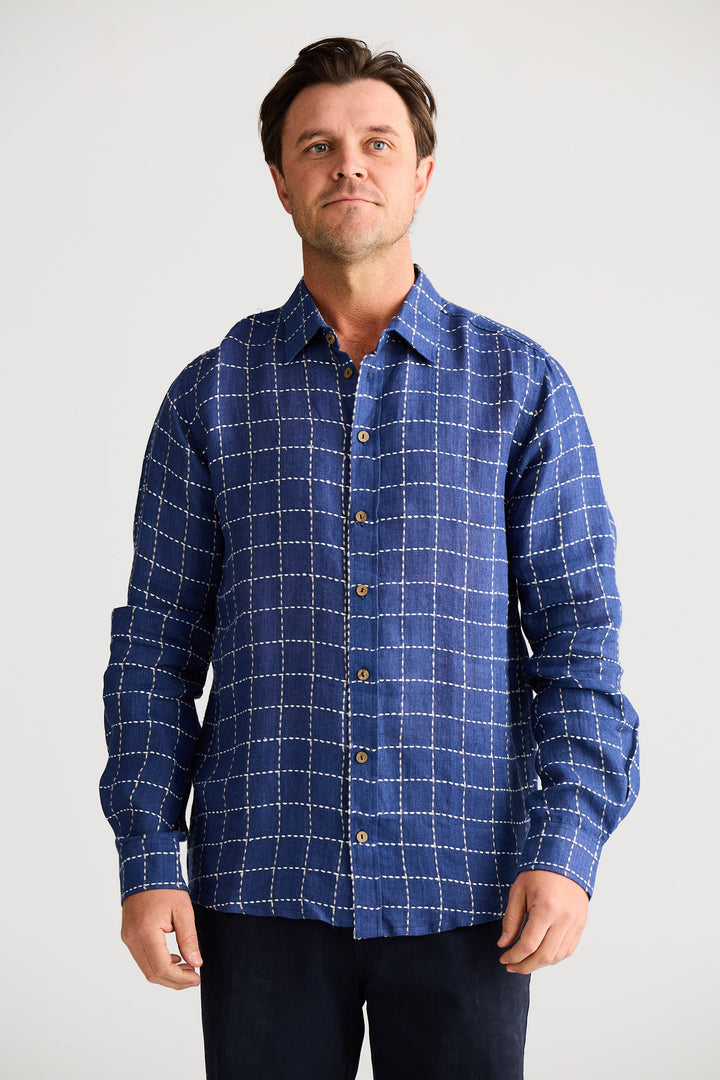 Man wearing a blue checkered shirt against a white background