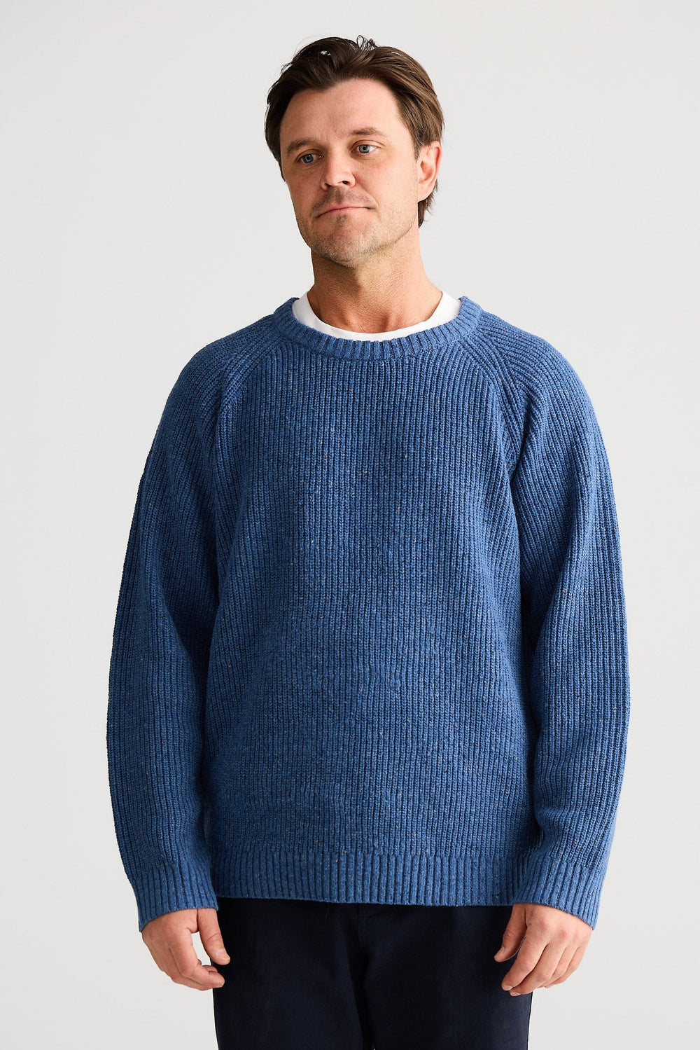 Man wearing a blue sweater against a plain background