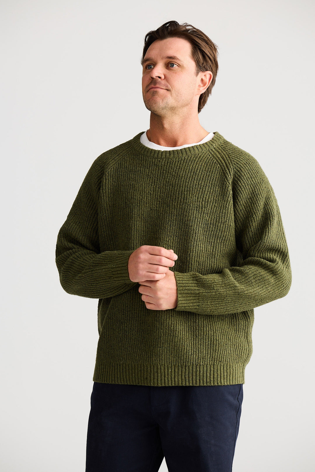 Man wearing a green sweater against a plain background