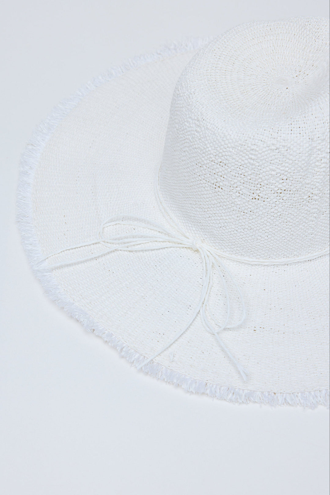Close-up of a textured white hat on a light gray background