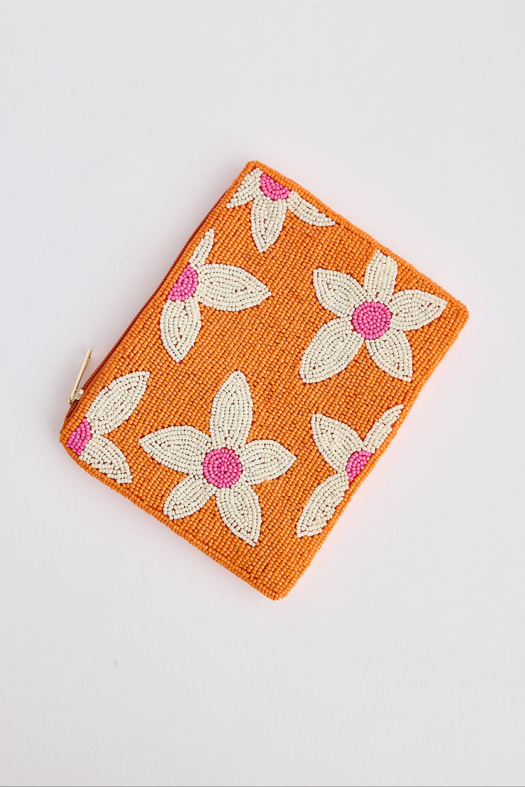 Orange pouch with floral patterns on a light gray background