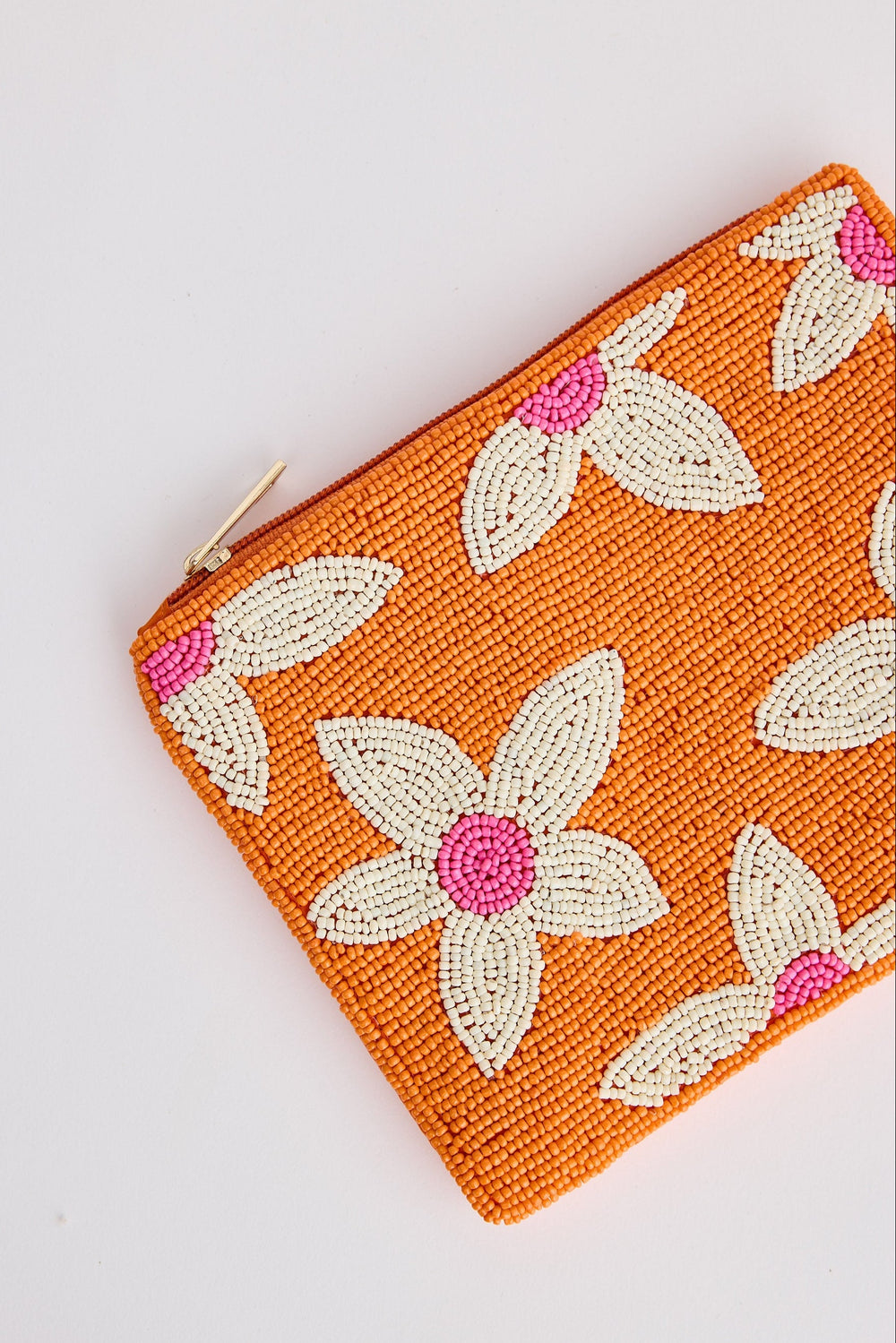 Orange pouch with floral patterns on a white background