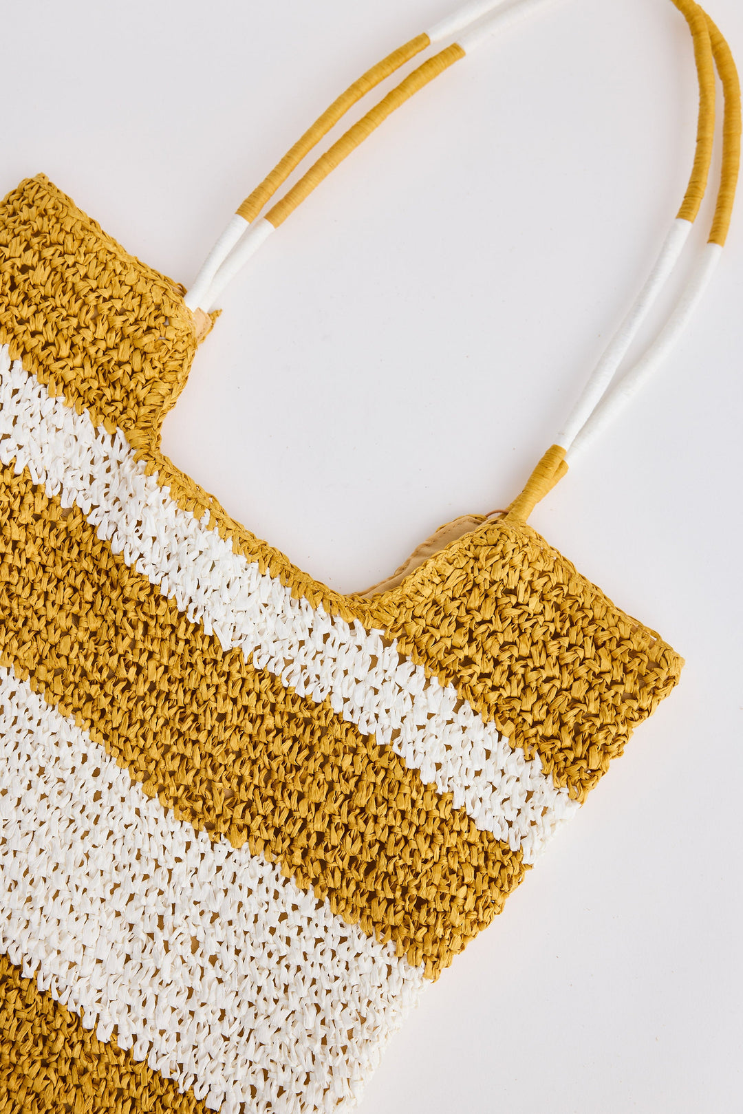 Woven bag with yellow and white stripes on a light background
