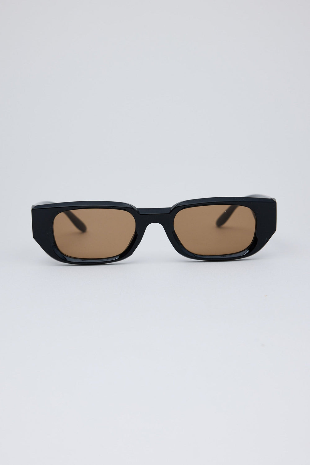 Black sunglasses with brown lenses on a white background