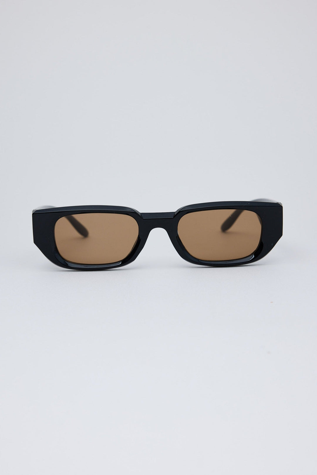 Black sunglasses with brown lenses on a white background