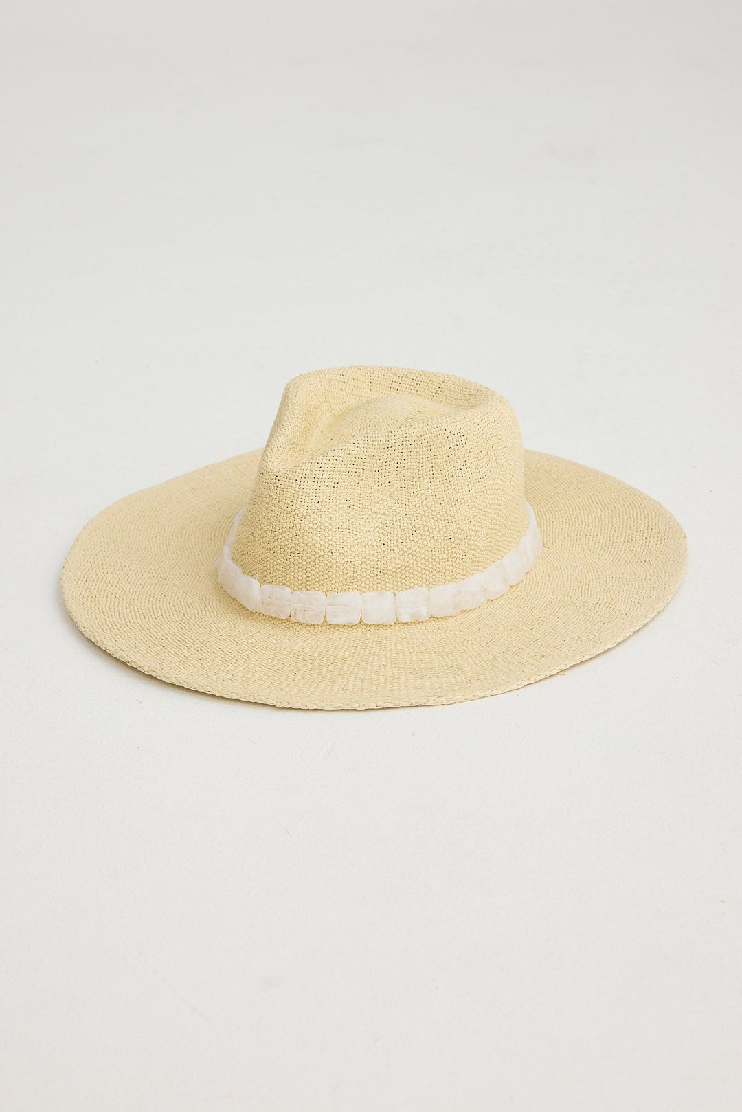 Natural straw hat with a white band on a light gray background