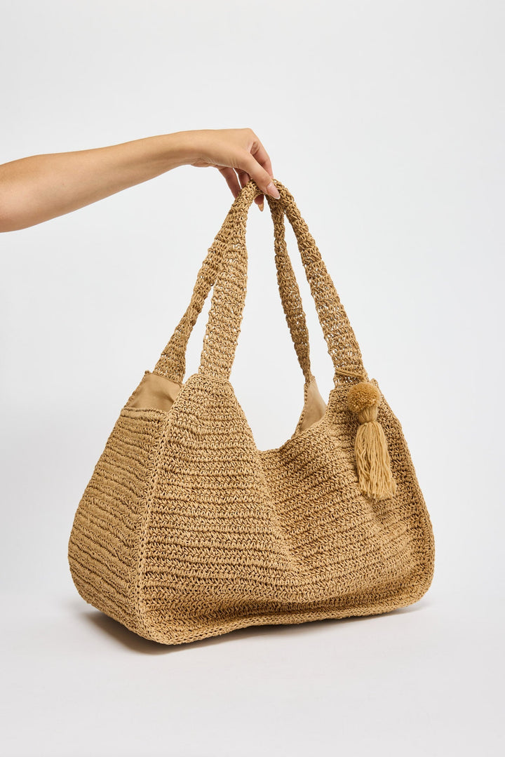 Nora Bag in natural tan - close-up of the tasselled pom-pom detail on the strap