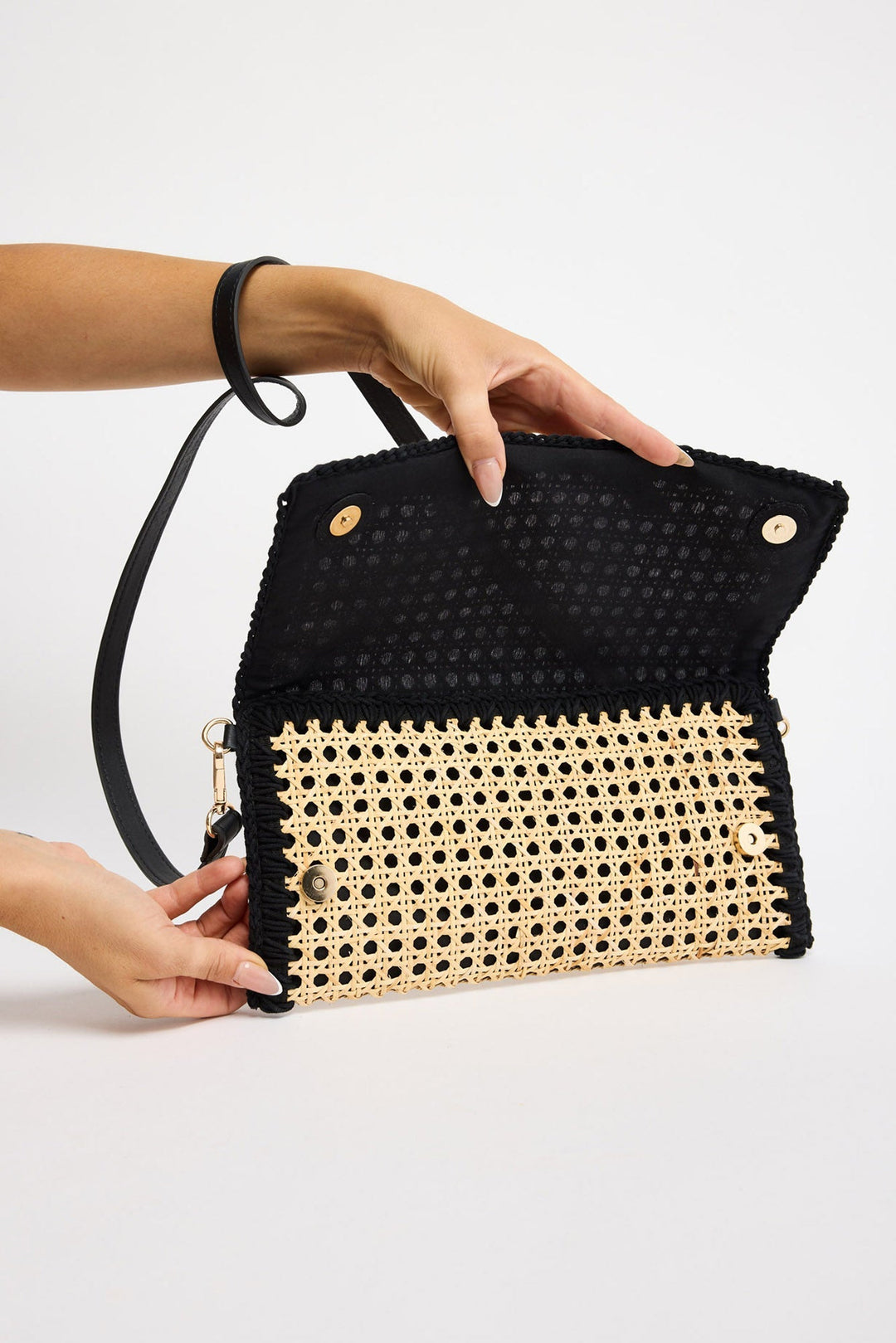 Reema Bag in black - open flap view showing the rattan weave and black macrame edging
