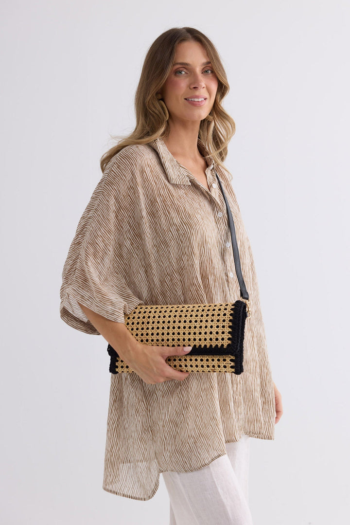 Reema Bag in black worn crossbody, side view over a striped outfit