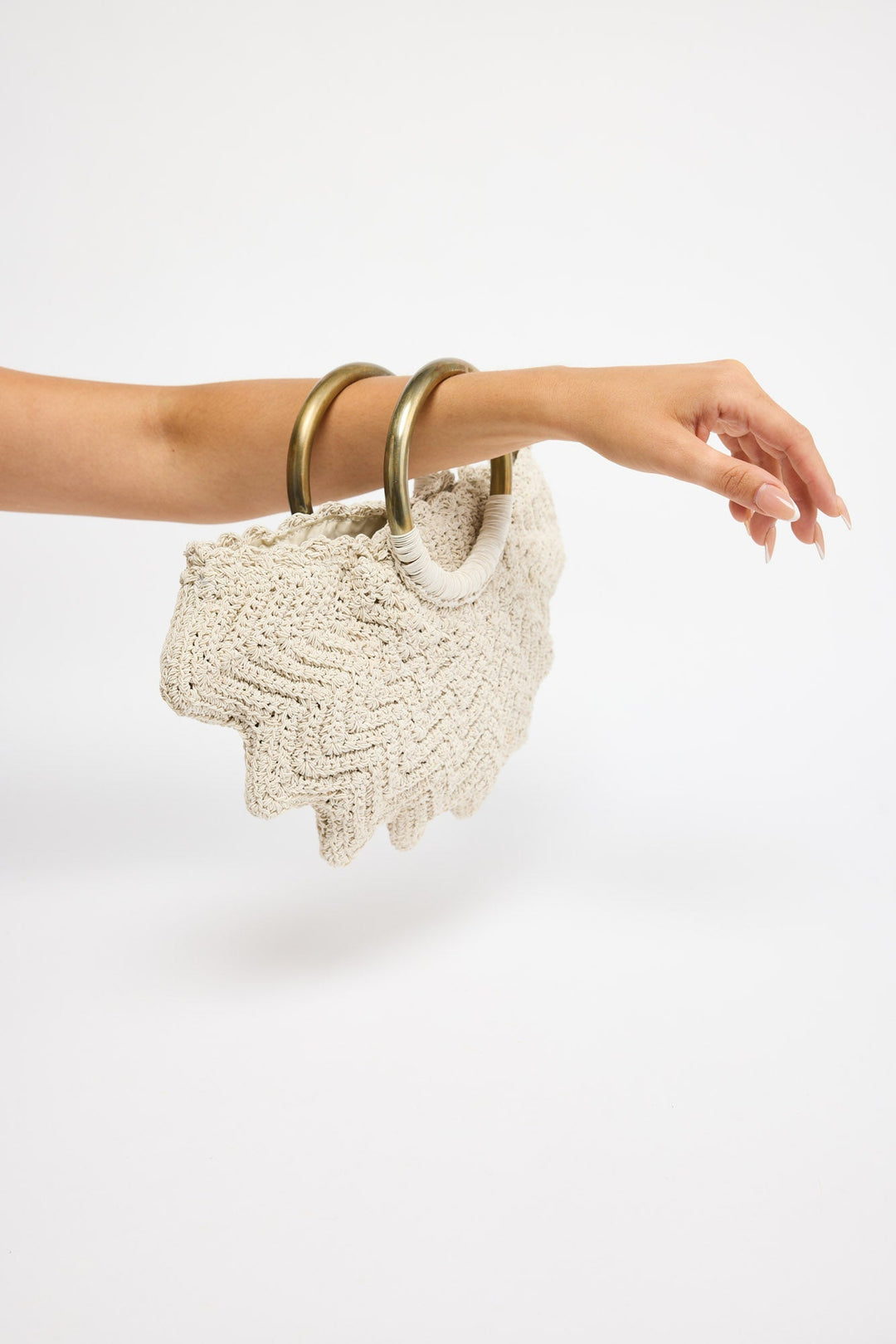 Santana Bag in off white - close-up of the ring handles wrapped in cream cord, held in hand