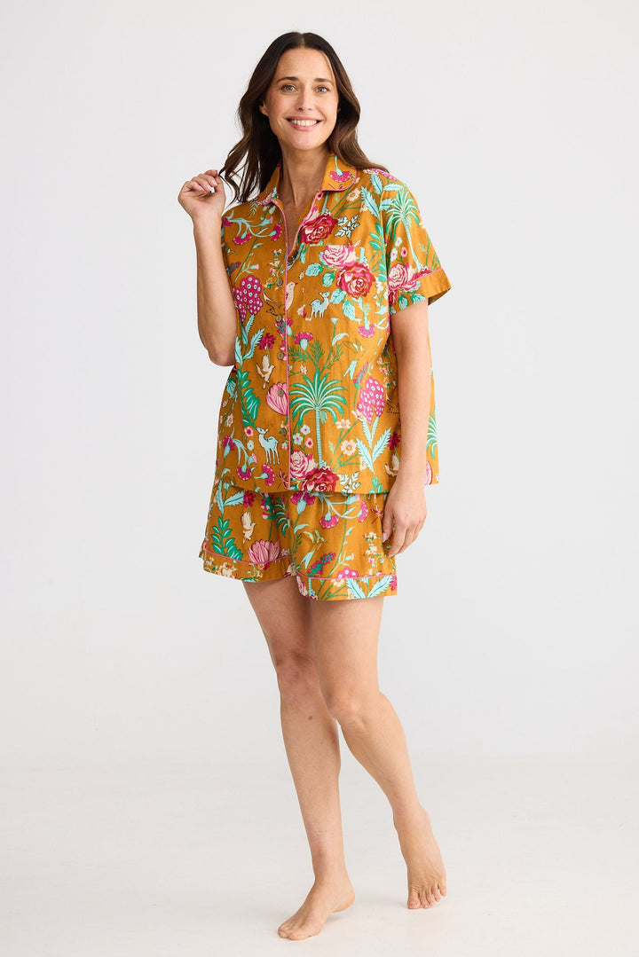 Woman wearing a colorful floral pajama set on a white background