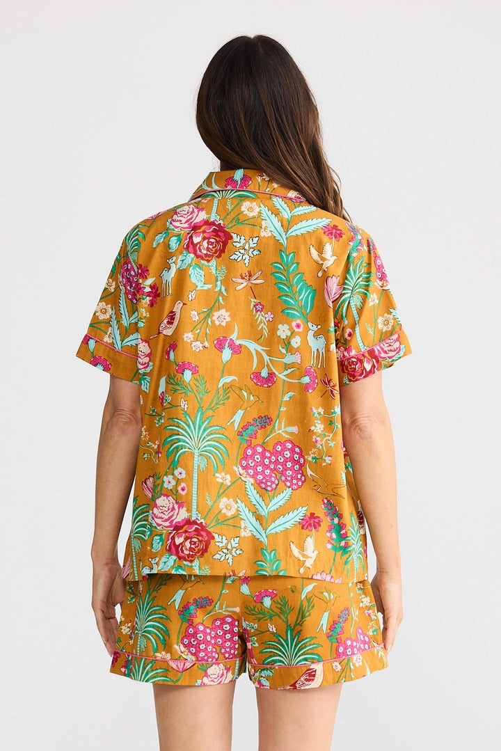 Woman wearing a colorful floral outfit on a white background