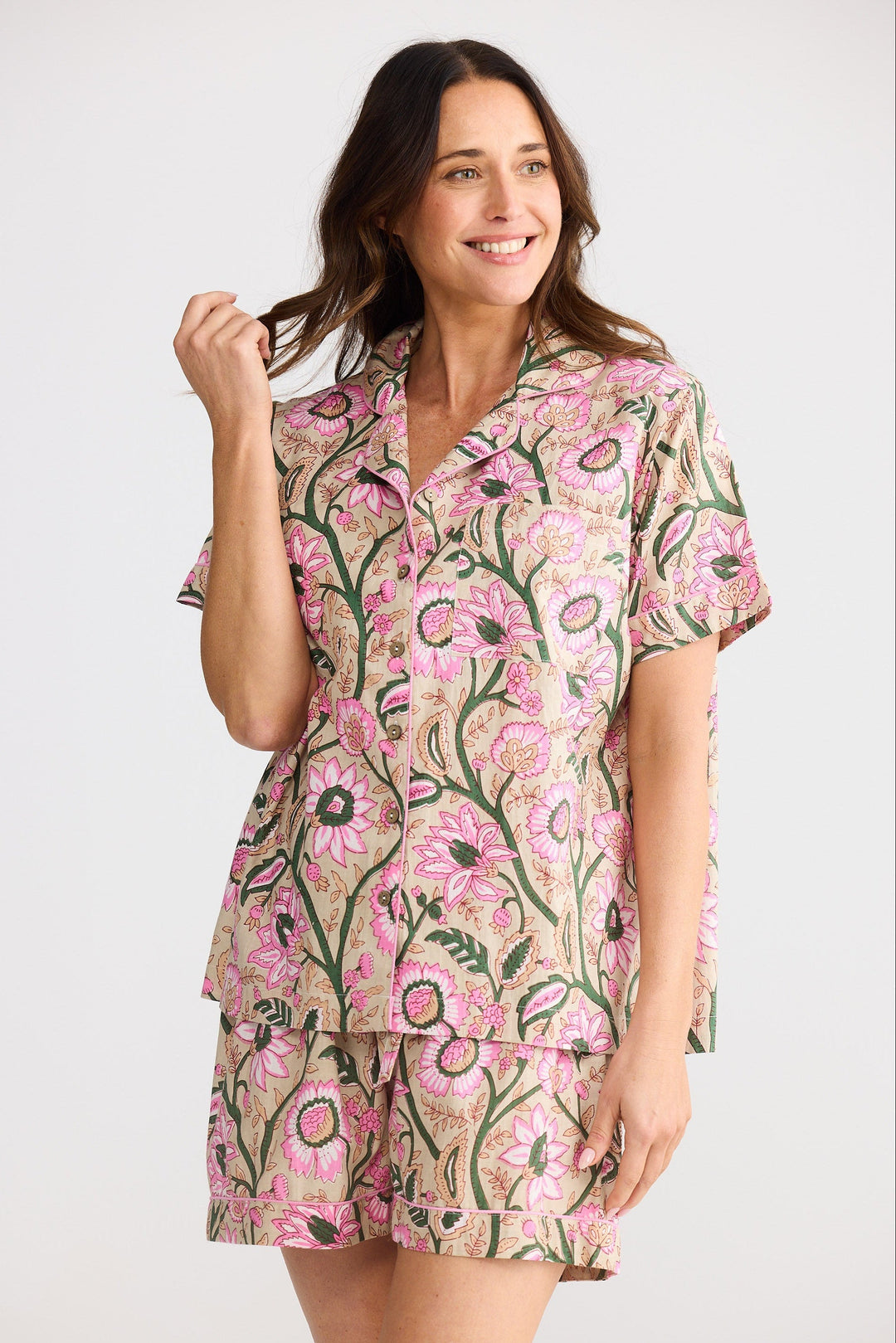 Woman wearing a floral pajama set on a white background