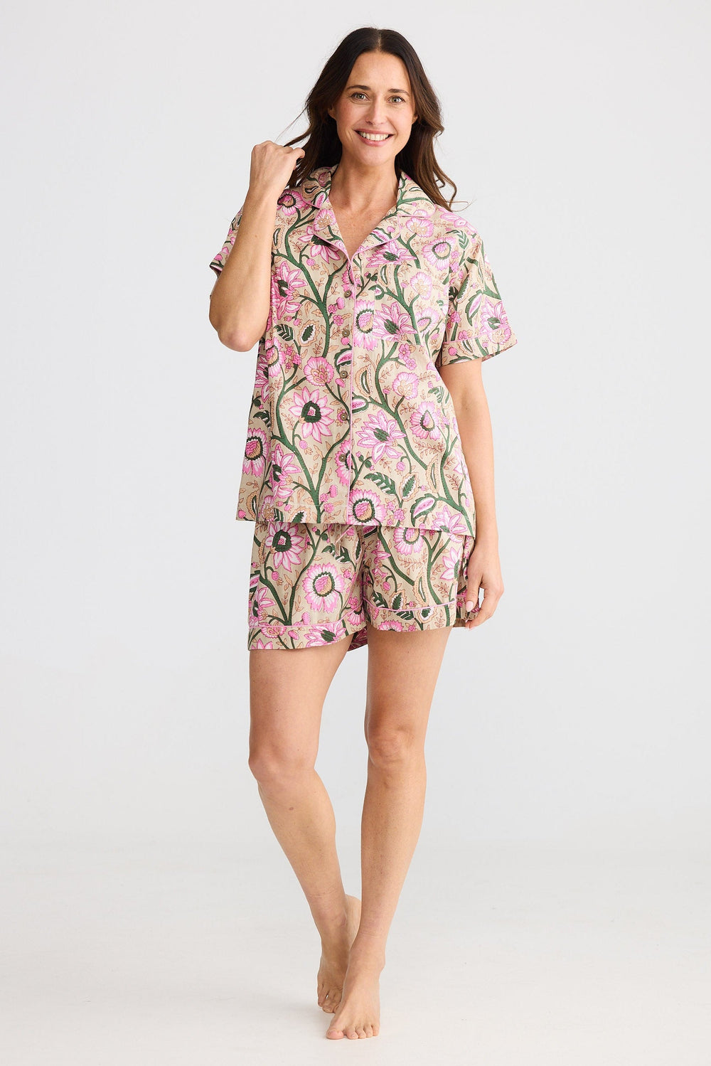 Woman wearing a pink floral pajama set on a white background
