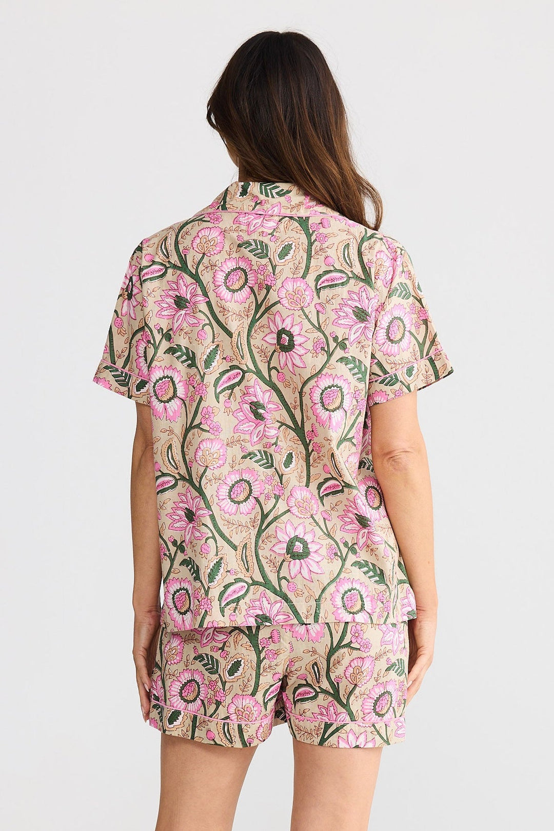 Woman wearing a floral pajama set on a white background