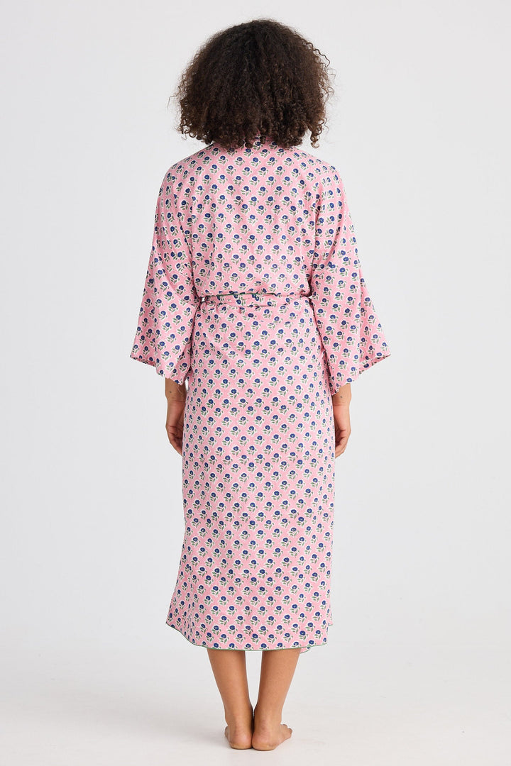 Woman wearing a pink patterned robe on a white background