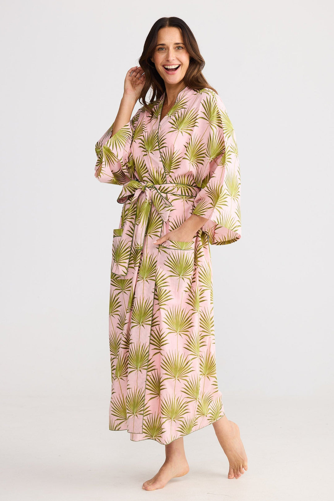 Woman wearing a pink and green patterned robe on a white background