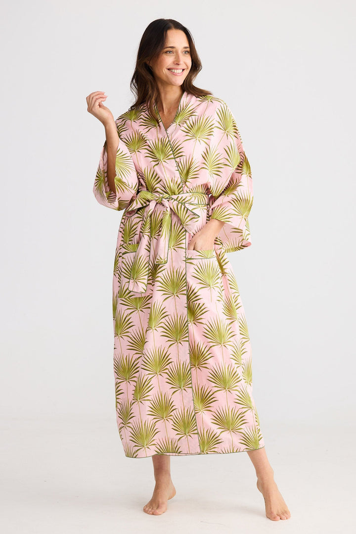 Woman wearing a pink and green patterned robe on a white background