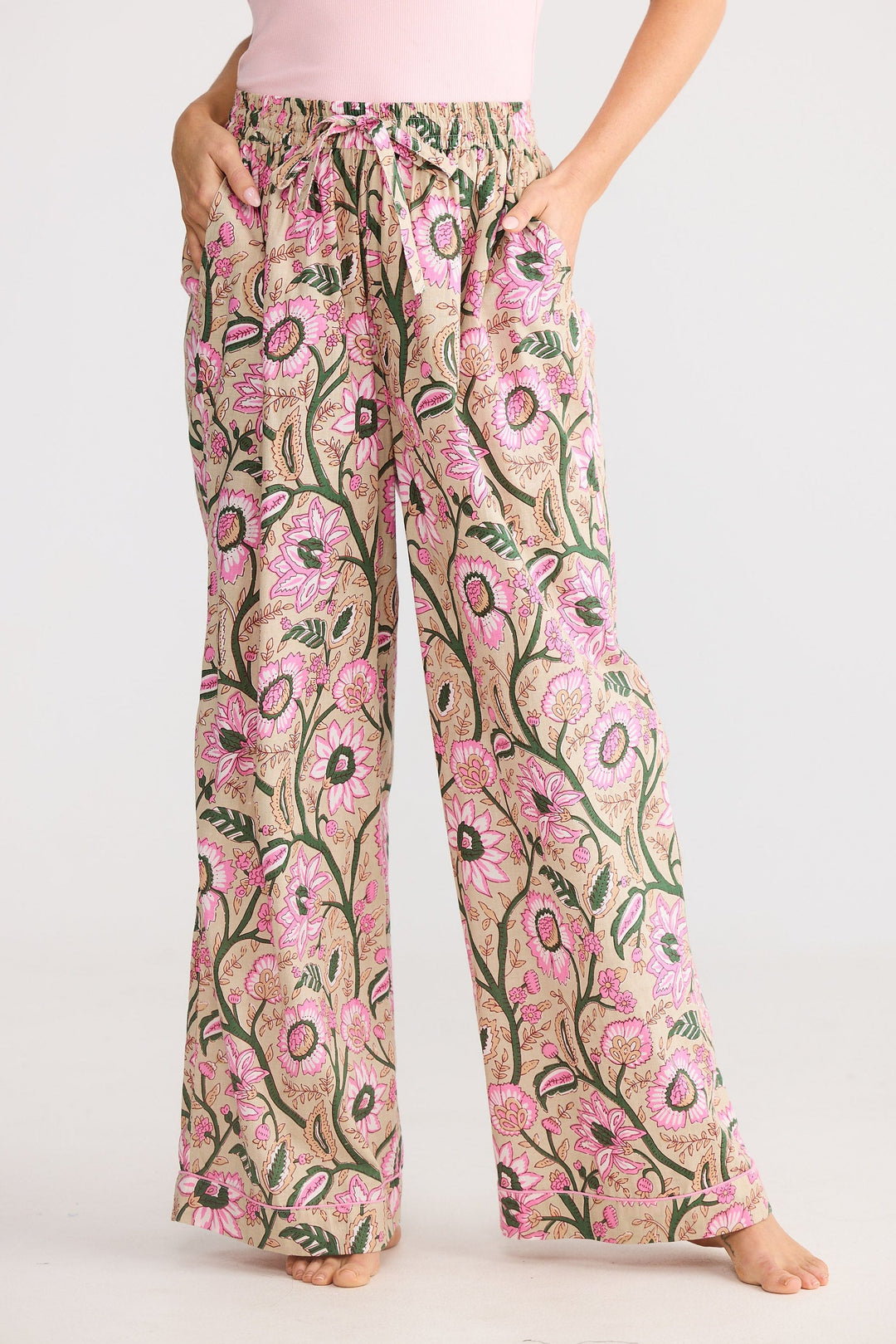 Floral patterned pants worn by a person on a white background