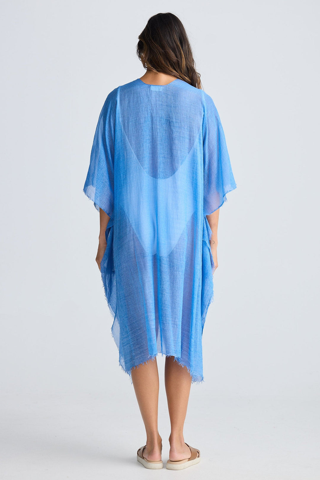 Woman wearing a blue cover-up against a white background