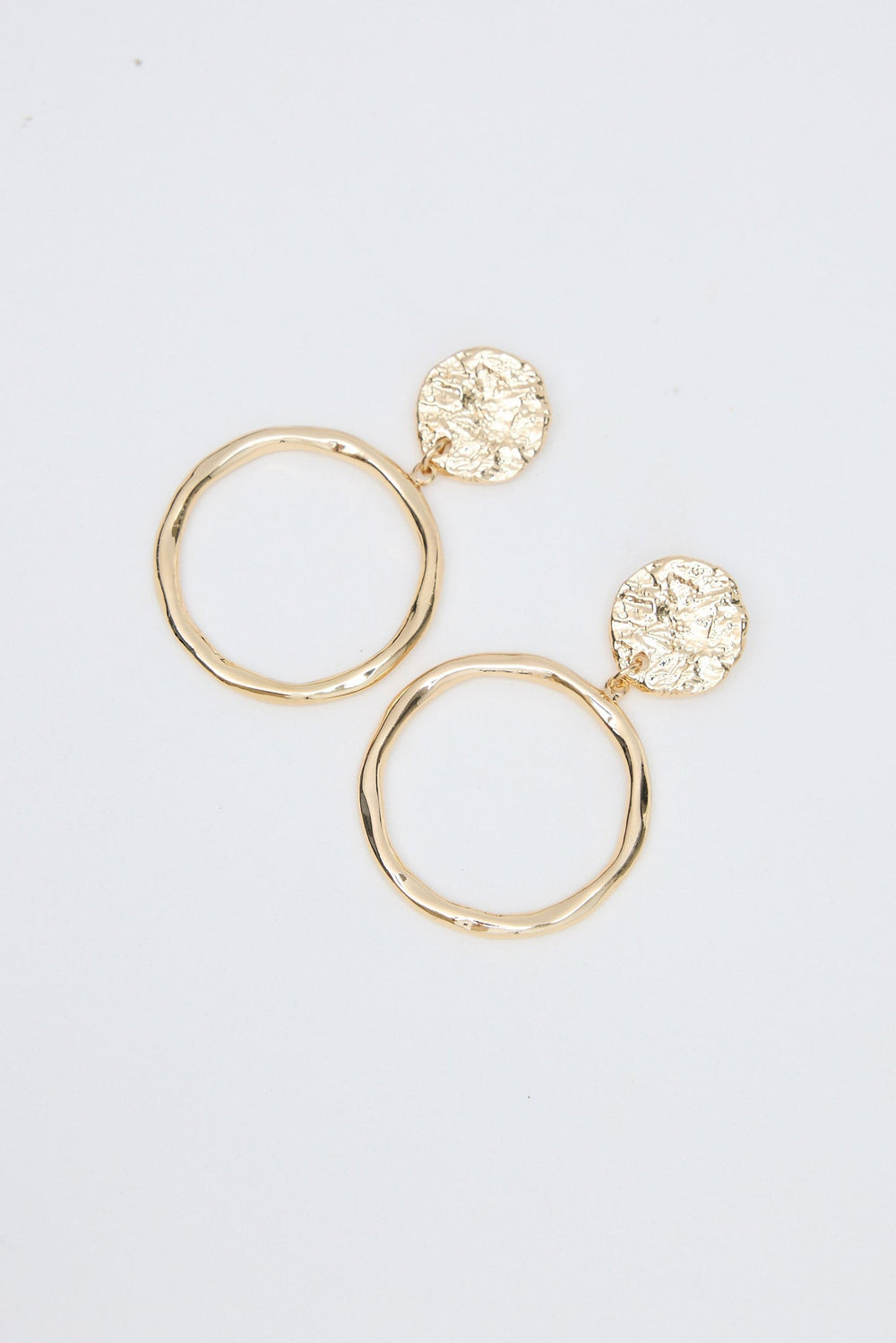 Gold hoop earrings with round embellishments on a light gray background