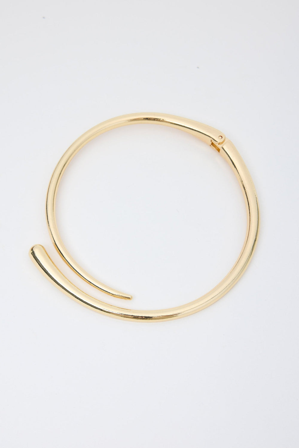 Gold necklace on a light gray background