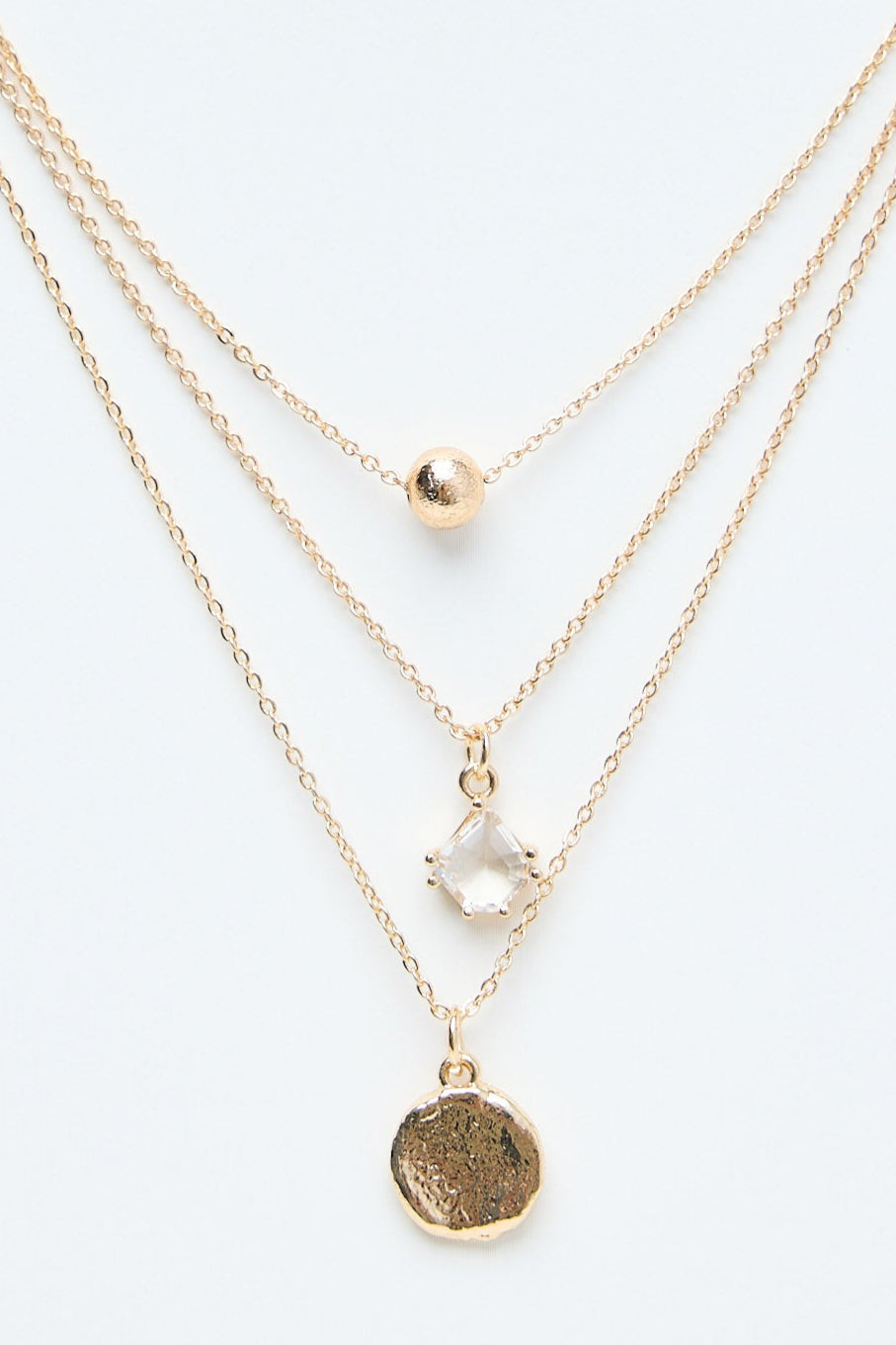 Gold necklaces on a mannequin with a white background