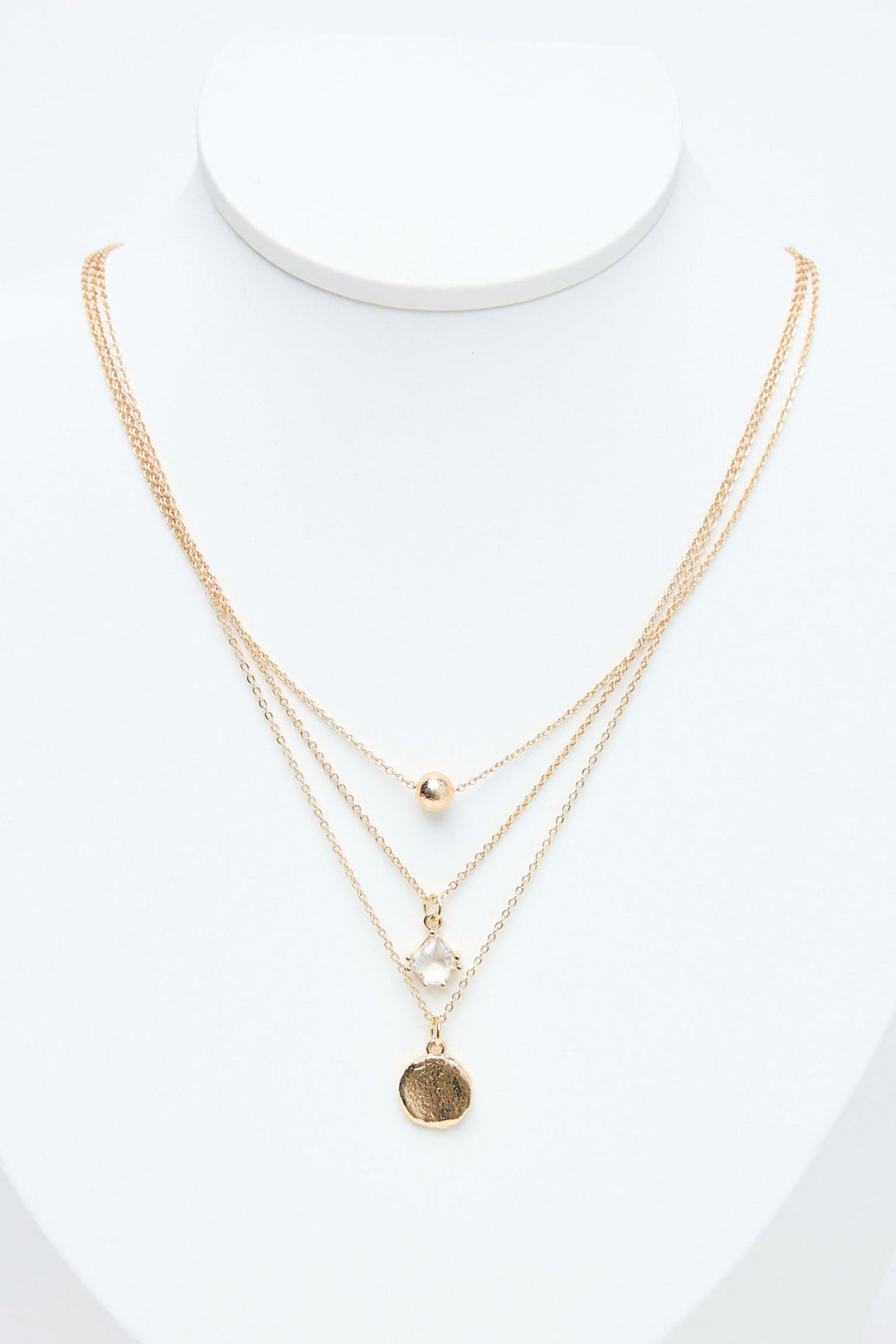 Gold necklaces on a mannequin with a white background