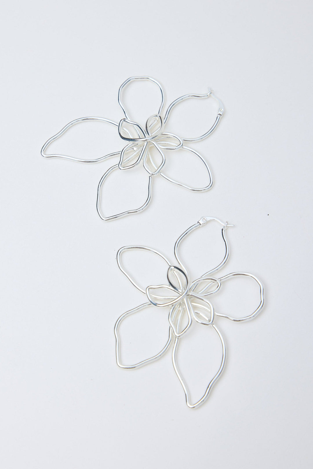 Silver flower-shaped earrings on a white background