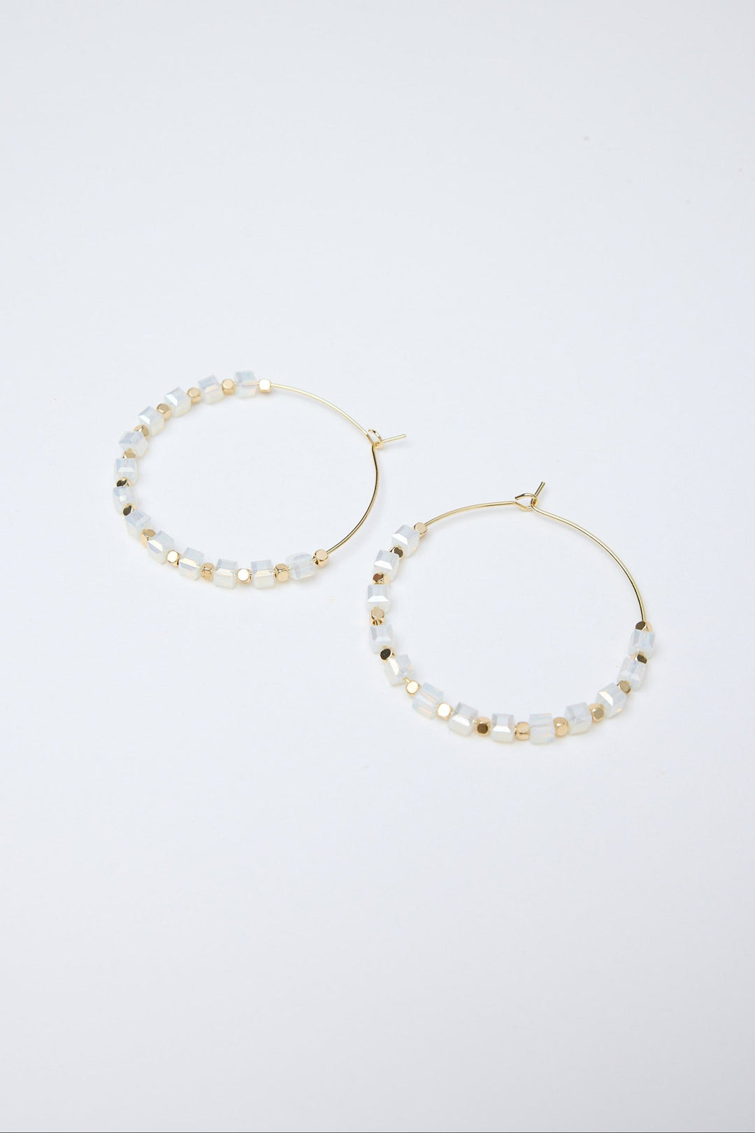 Pair of hoop earrings with pearl-like beads on a white background