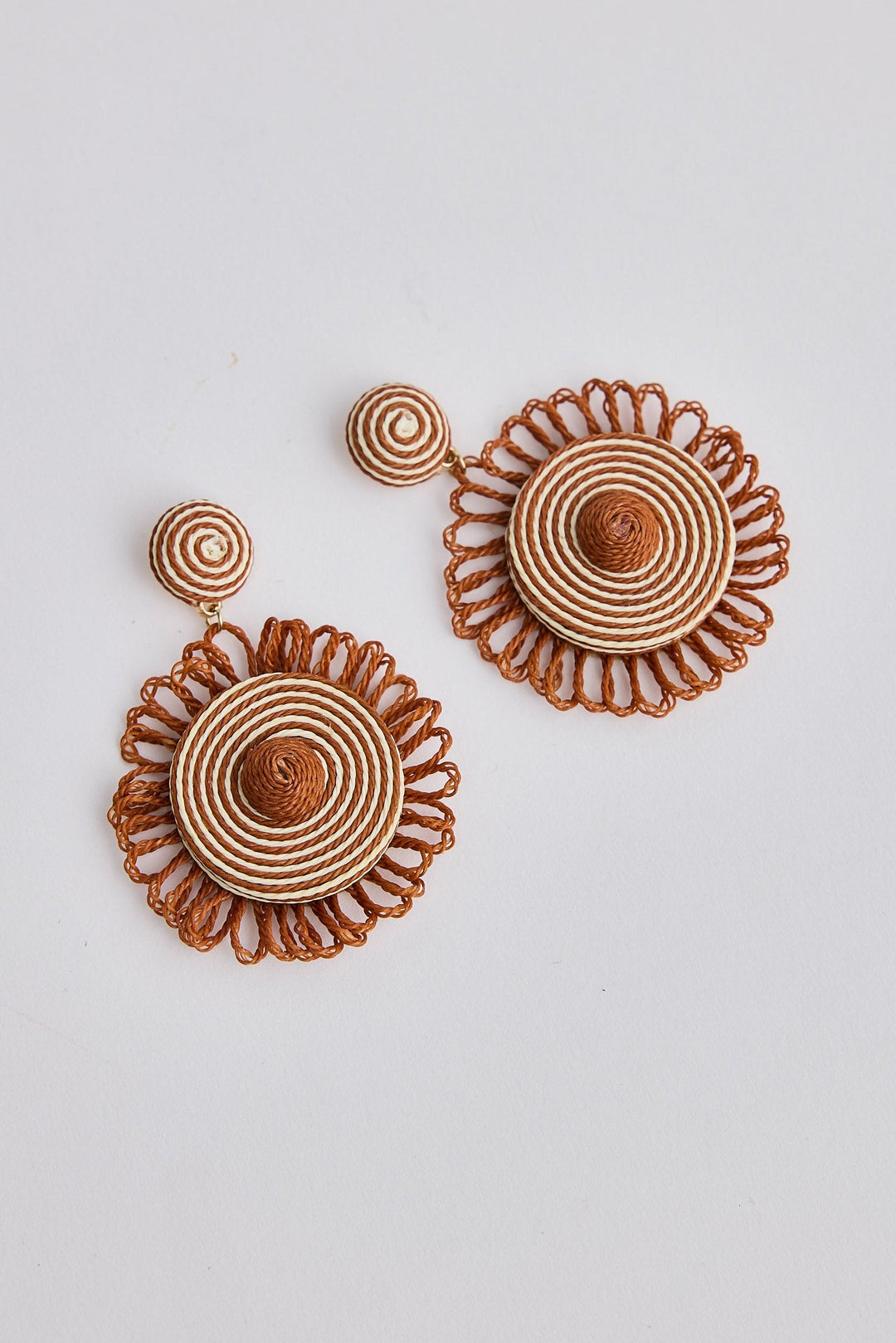 Pair of brown floral earrings on a light gray background