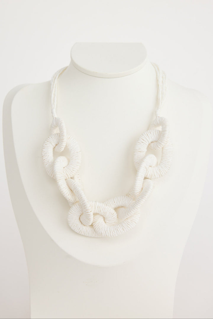 White necklace on a mannequin against a white background