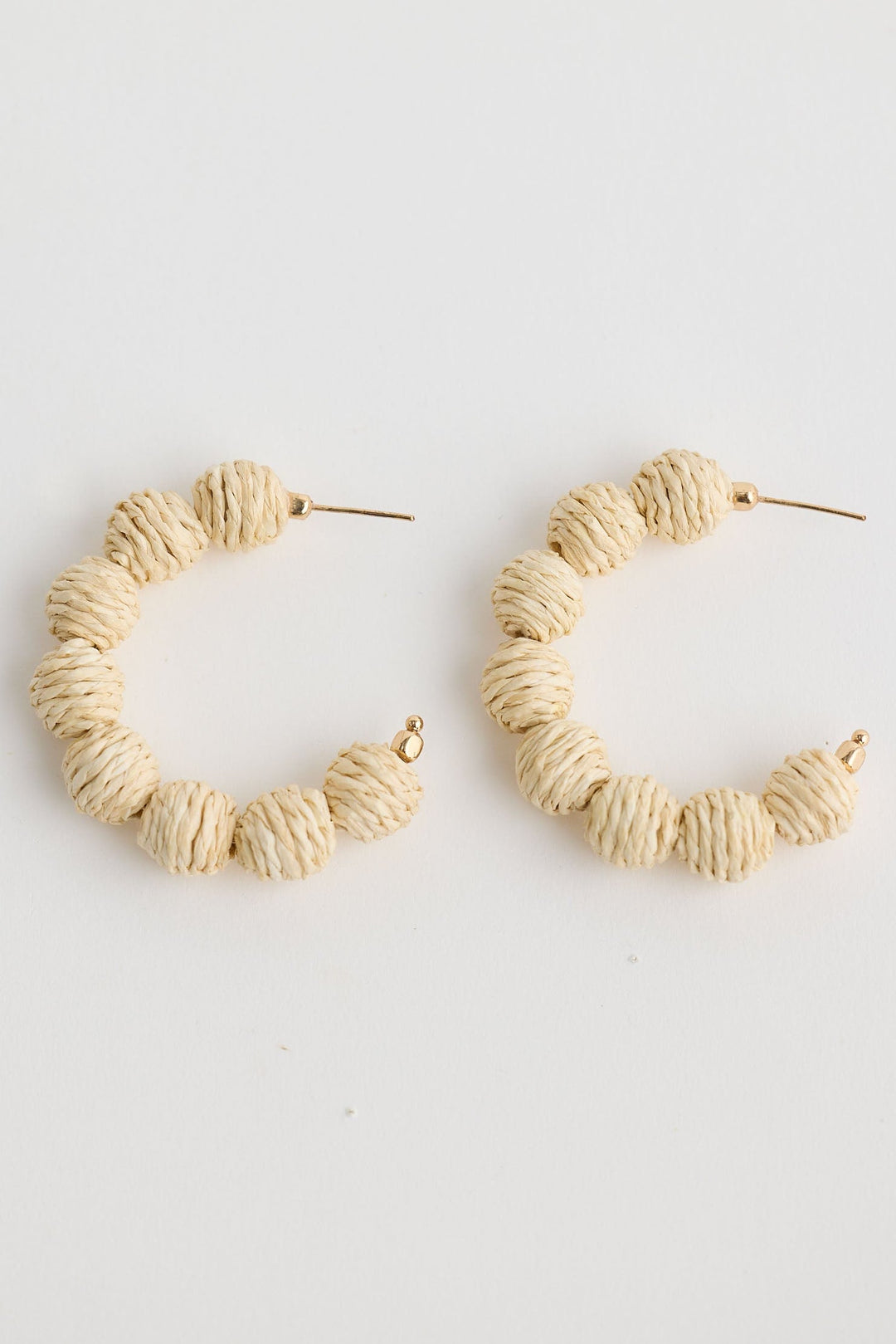 Close-up of natural waldorf hoops earrings on white background.