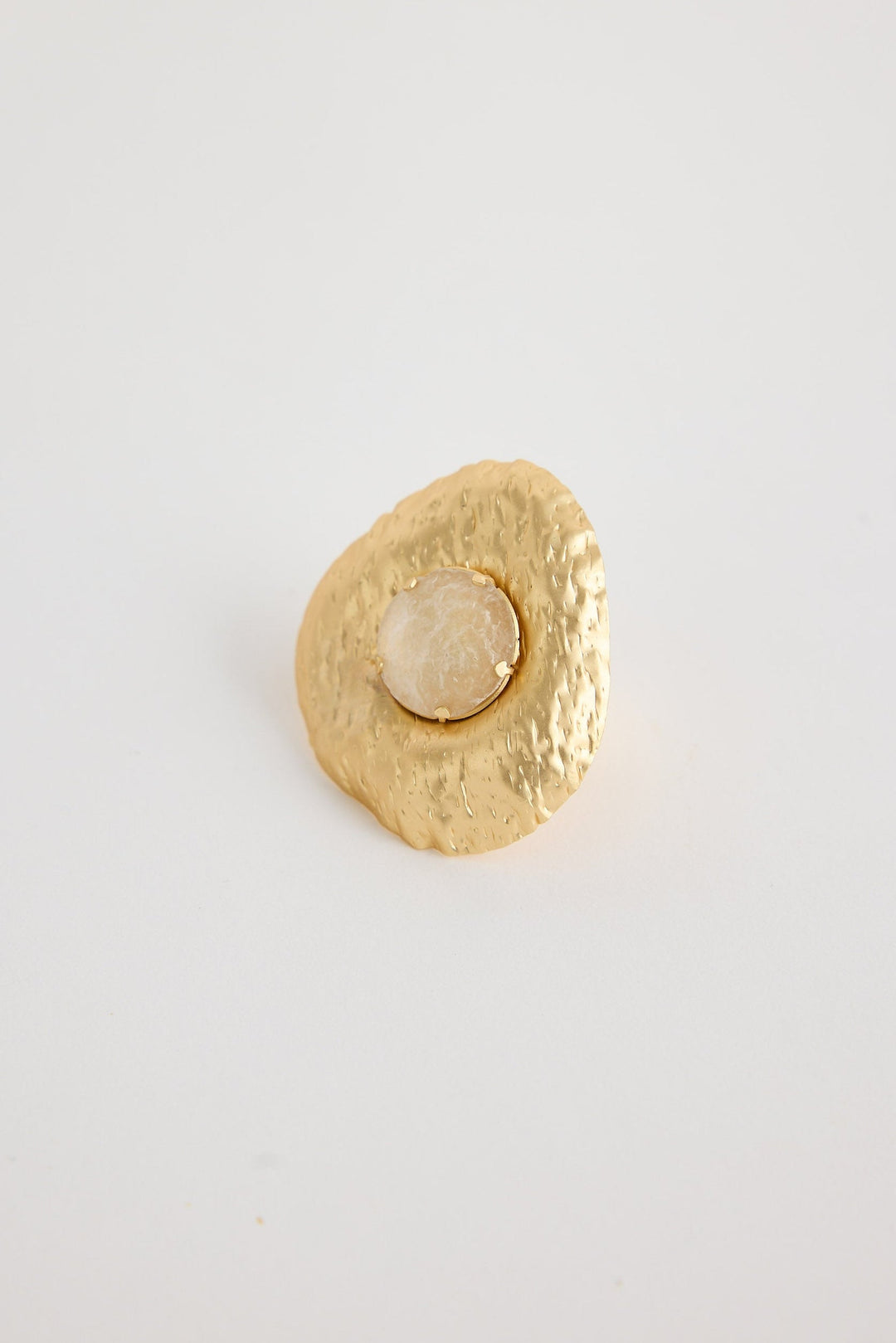 Gold textured round ring on a light gray background
