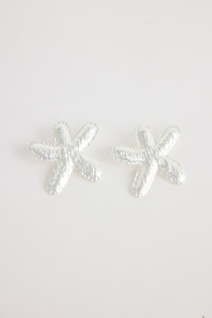 Silver starfish-shaped earrings on a white background