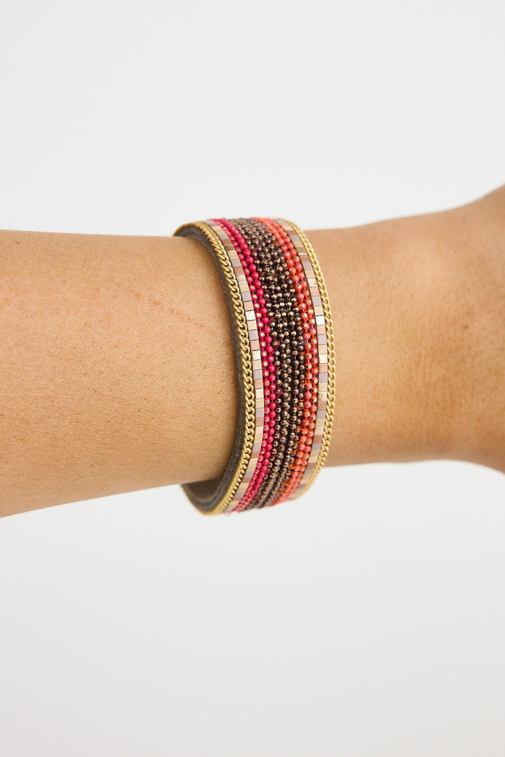 Multicolored beaded bracelet on a wrist against a white background