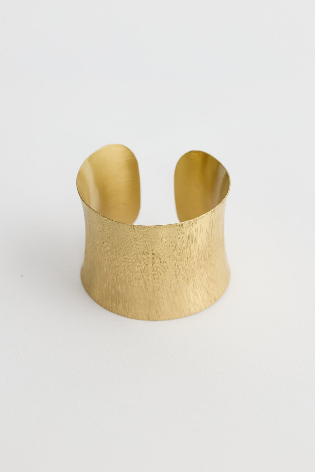 Gold cuff bracelet on a white background