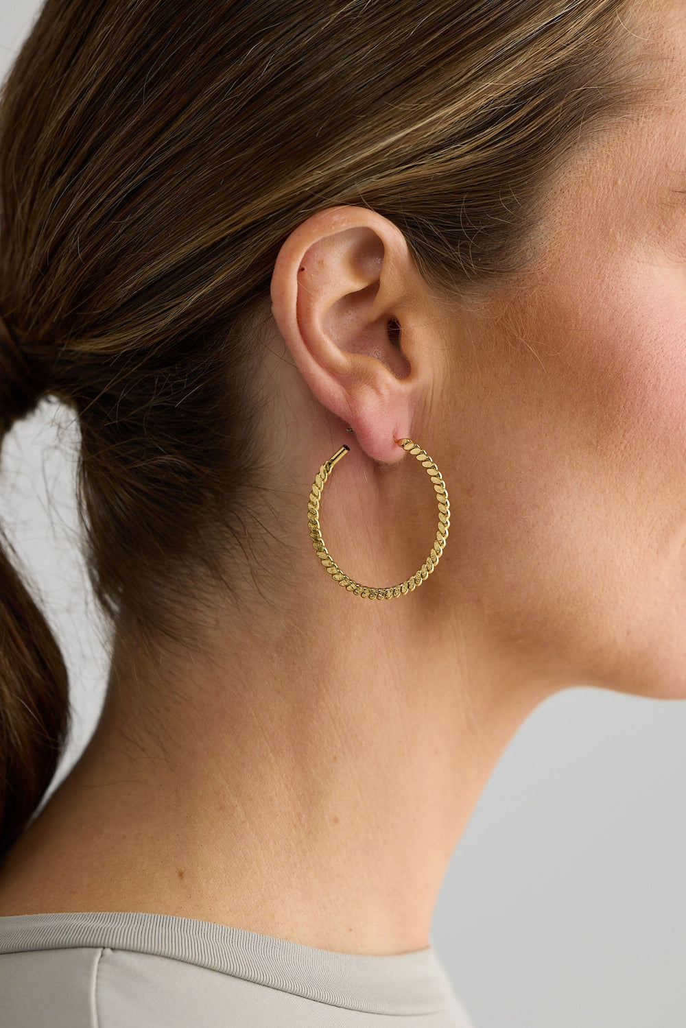 Close-up of gold oscar earrings earrings on white background.