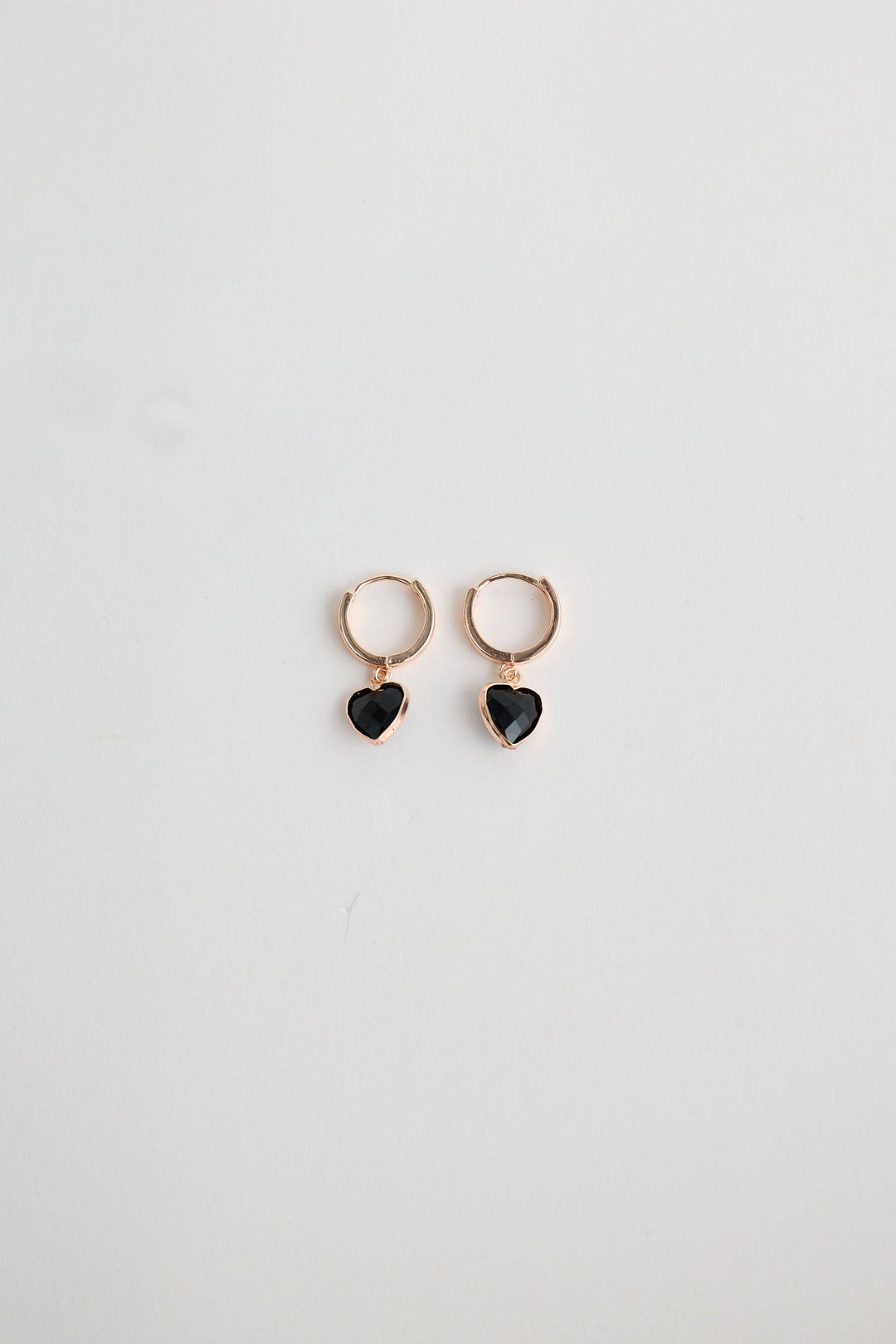 Close-up of black adore earrings earrings on white background.