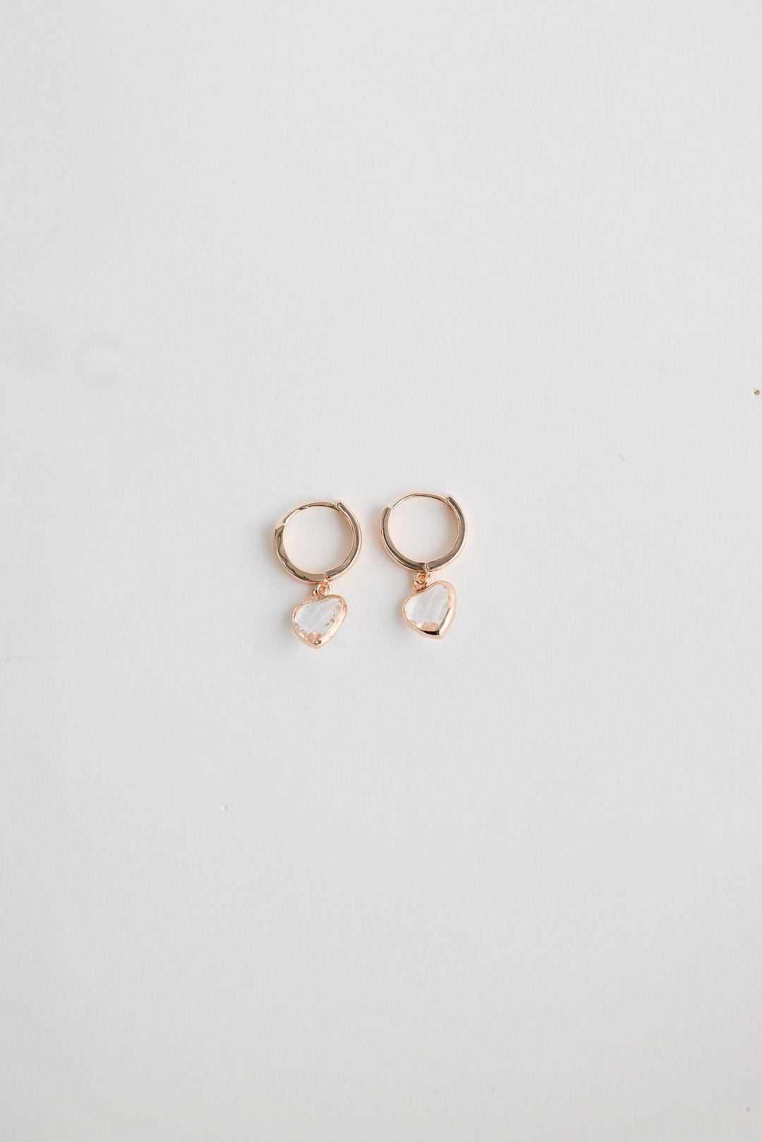 Close-up of clear adore earrings earrings on white background.