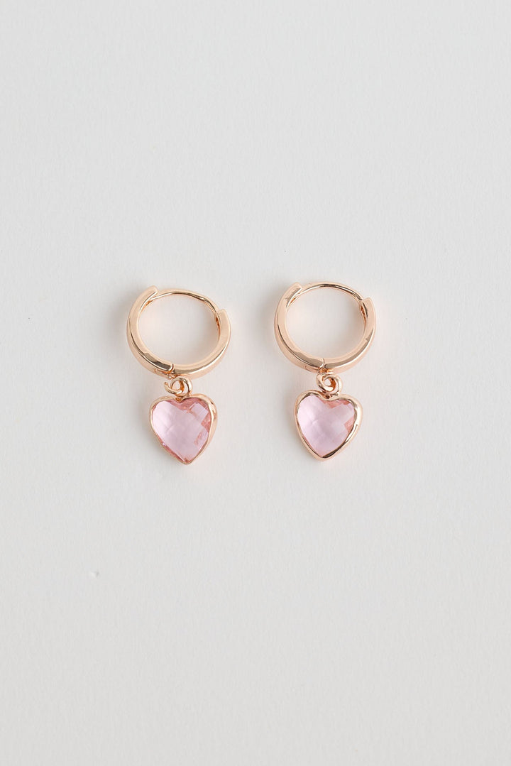 Close-up of rose gold adore earrings earrings on white background.