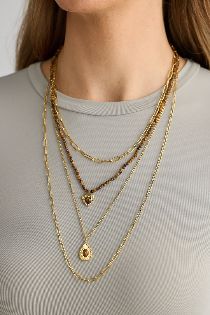 Close-up of gold alex necklace necklace on white background.